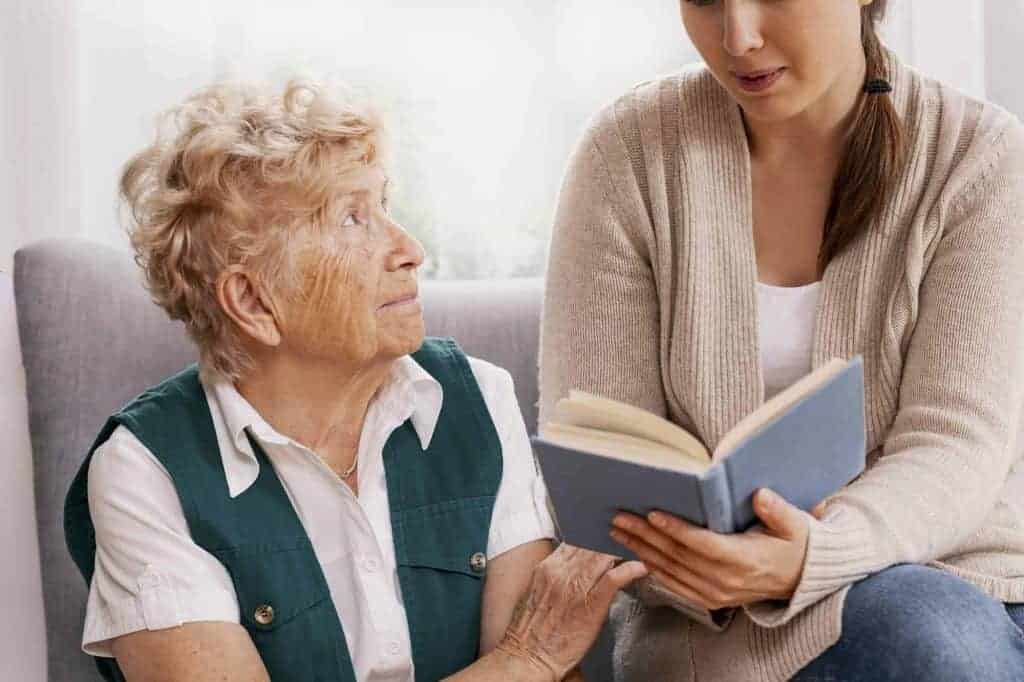 Grandmother and granddaughter spend time together reviewing the photo album